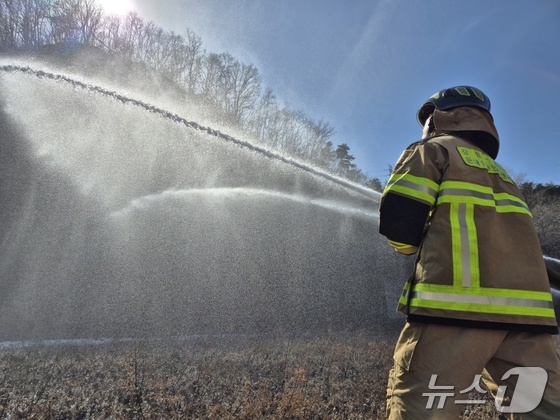 Firefighters participated in a large-scale wildfire preparedness and response exercise organized by the Gangwon Provincial Fire Department at the former site of Hanzhong University in Donghae City, South Korea. During the drill, firefighters were seen carrying out water-spraying operations as part of their efforts to simulate a response to a major wildfire. / News1