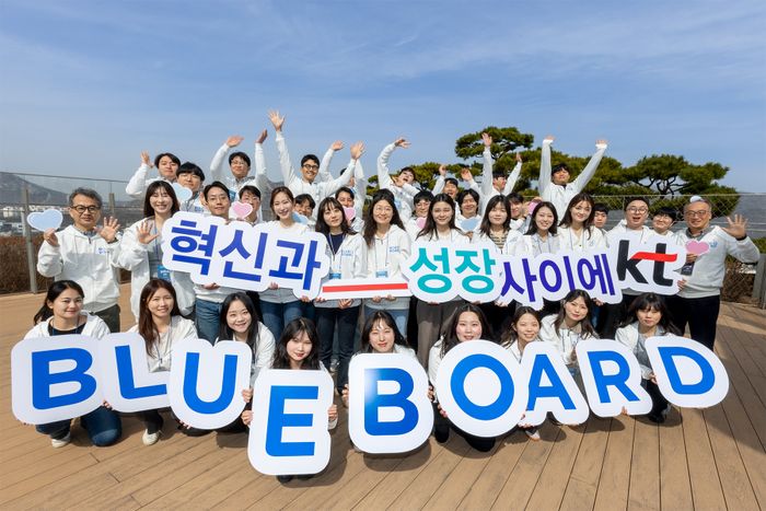 2025년 KT 블루보드로 선발된 직원들이 올해 활동 슬로건인 ‘KT, 혁신과_성장 사이에’와 함께 기념 촬영을 하고 있다. 기념 촬영에는 KT 경영지원부문장 임현규 부사장(둘째 줄 왼쪽 첫 번째) 등이 참석했다.ⓒKT