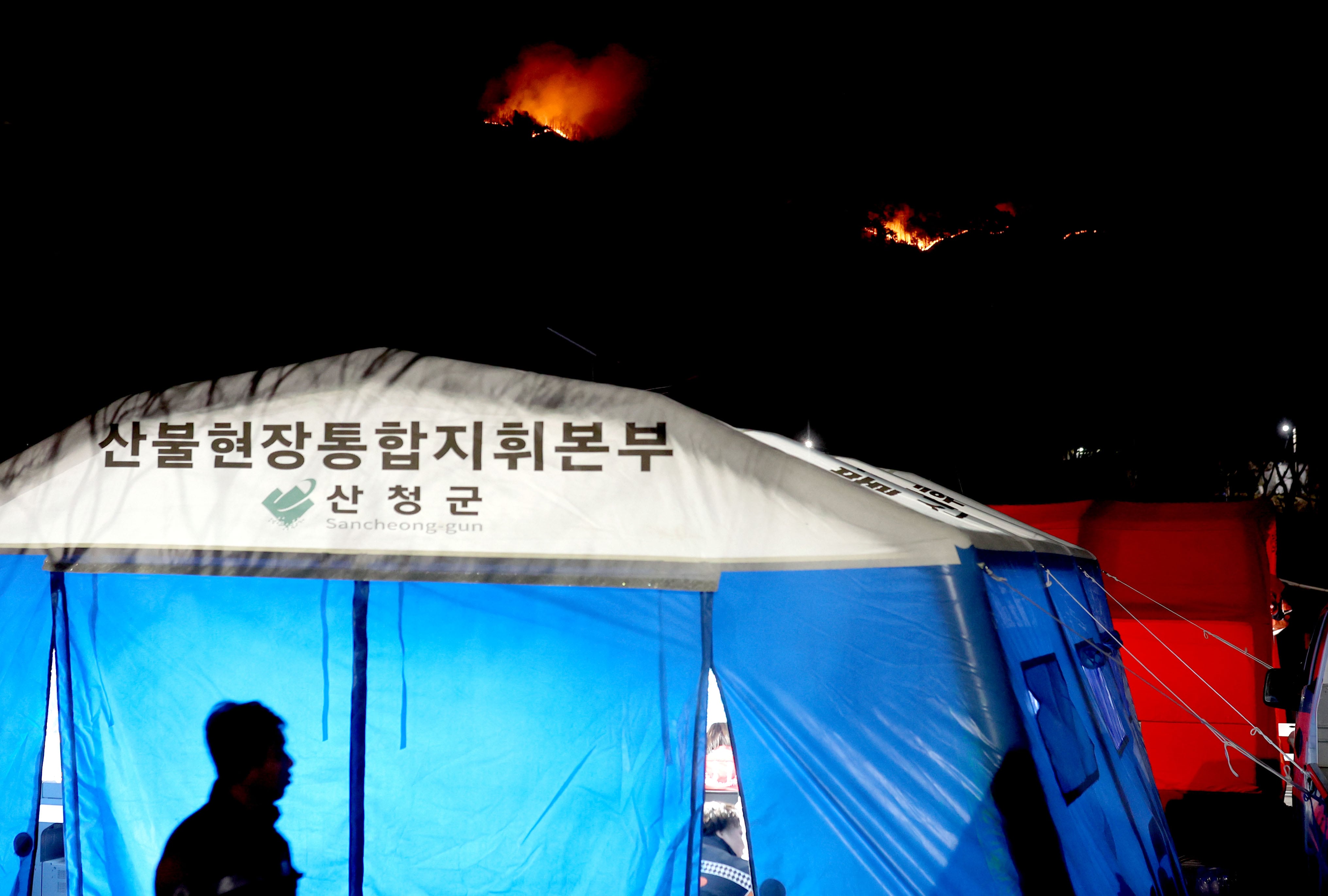 24일 오후 경남 산청군 시천면 산불현장통합지휘본부 뒤로 산불이 이어지고 있다. /연합뉴스