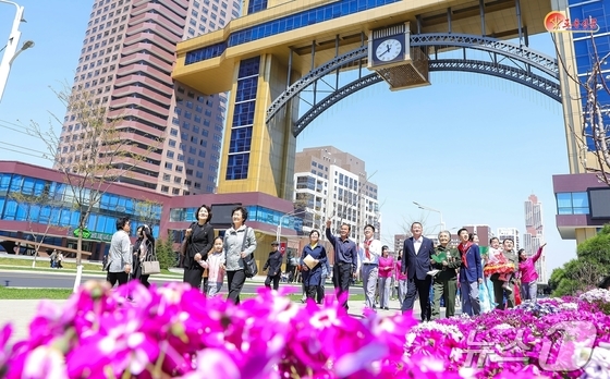 North Korea\'s Workers\' Party newspaper, Rodong Sinmun, reported on Monday that the third phase of the Hwasong district, which began moving in, is buzzing with \'new houses on a slope\'. One resident shed tears of joy as she unloaded her belongings and received her house key / Rodong Sinmun
