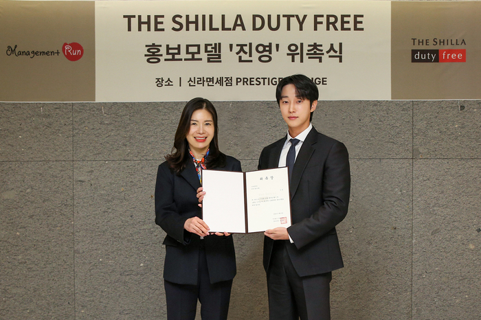 이 달 9일 신라면세점 서울점에서 진행된 신라면세점 홍보모델 '진영' 위촉식에서 김보연 신라면세점 마케팅 팀장(상무)(좌)과 홍보모델 진영(우)이 기념사진을 촬영하고 있다.