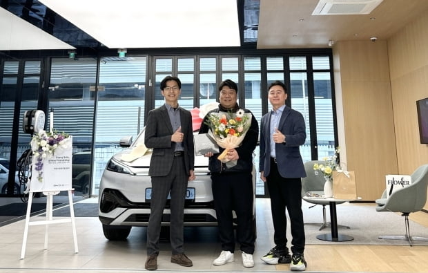 BYD 공식 딜러 하모니오토모빌 강서 전시장에서 황대갑 하모니오토모빌 대표(왼쪽 첫번째)와 아토3 1호 고객(왼쪽 두번째)이 기념촬영을 하고 있다