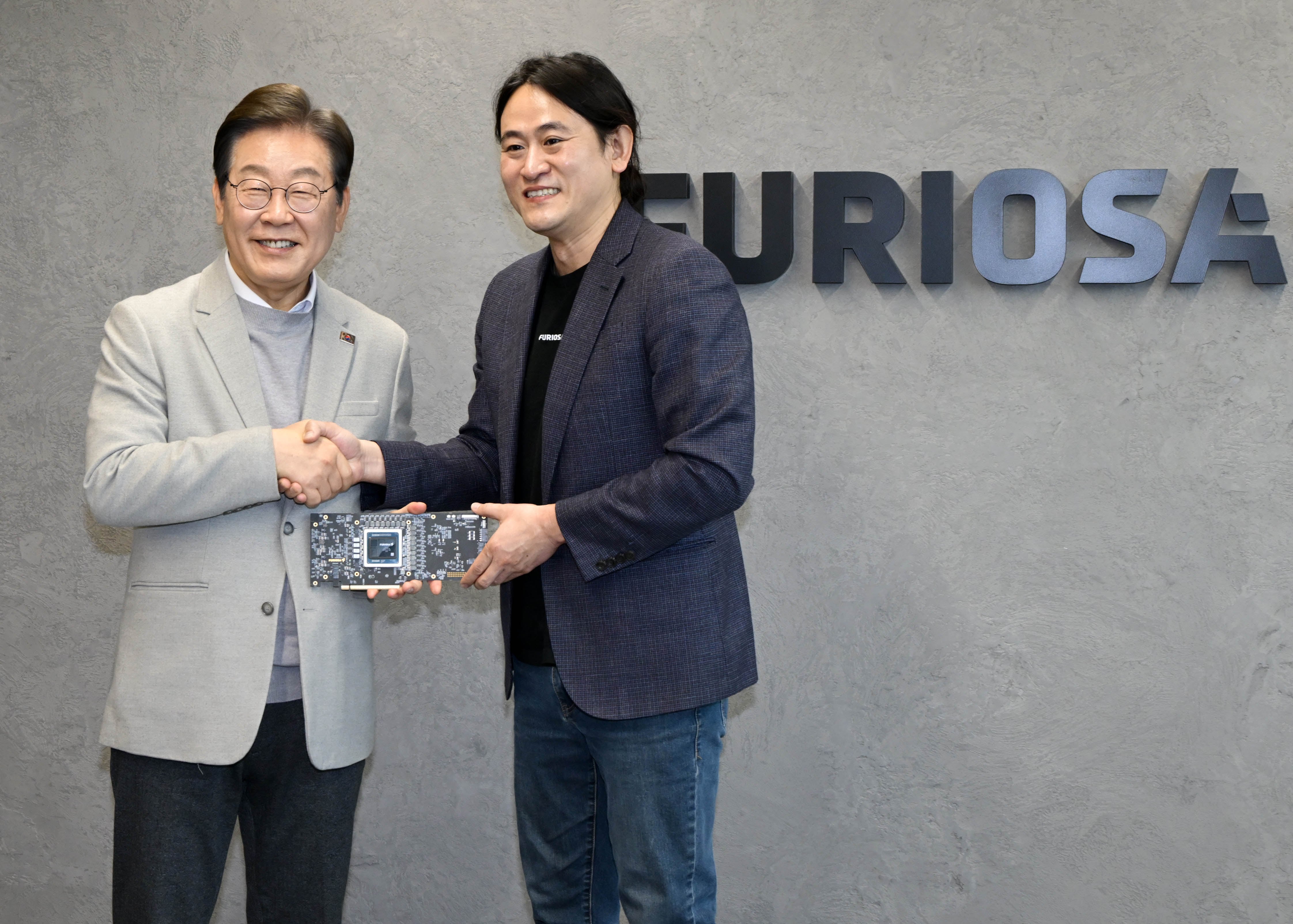 이재명 더불어민주당 대선 예비후보가 지난 14일 서울 강남구 퓨리오사AI에서 AI 칩을 들고 백준호 퓨리오사AI 대표와 악수하고 있다./국회사진기자단