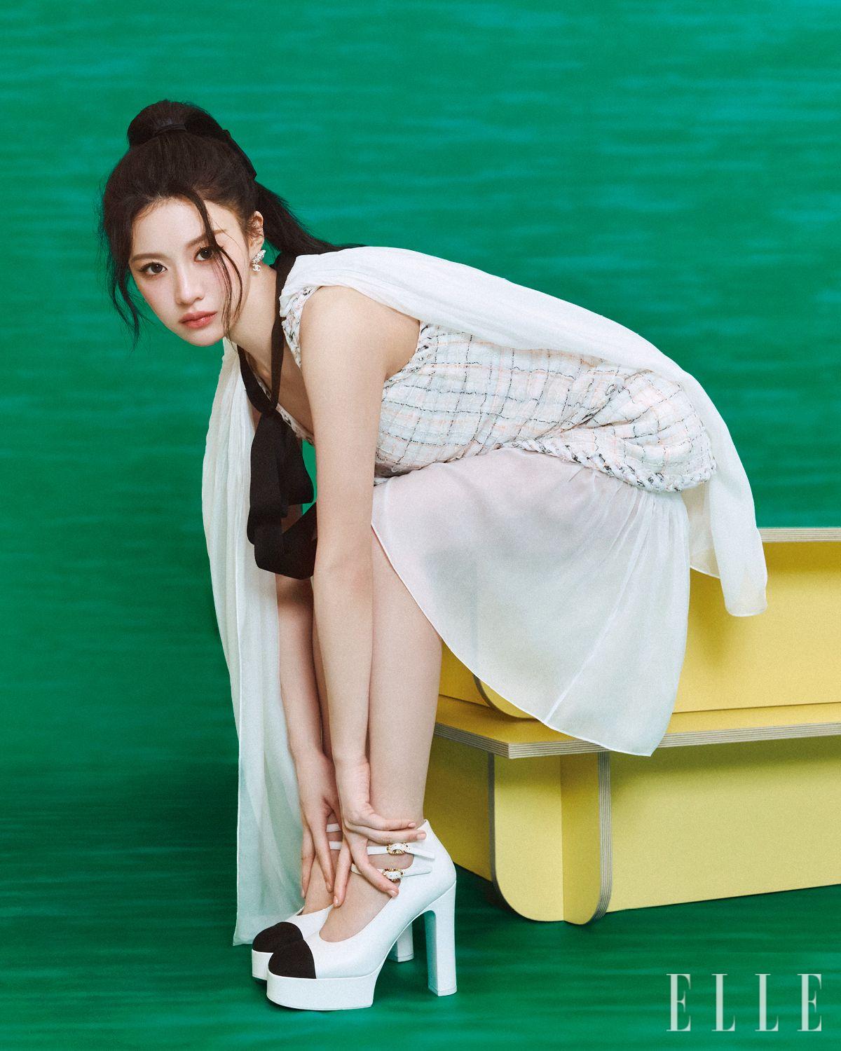 실크 모슬린 케이프와 체크 트위드 튤 드레스, 실크 드레스, 로고 이어링, 메리 제인 슈즈는 모두 Chanel.
