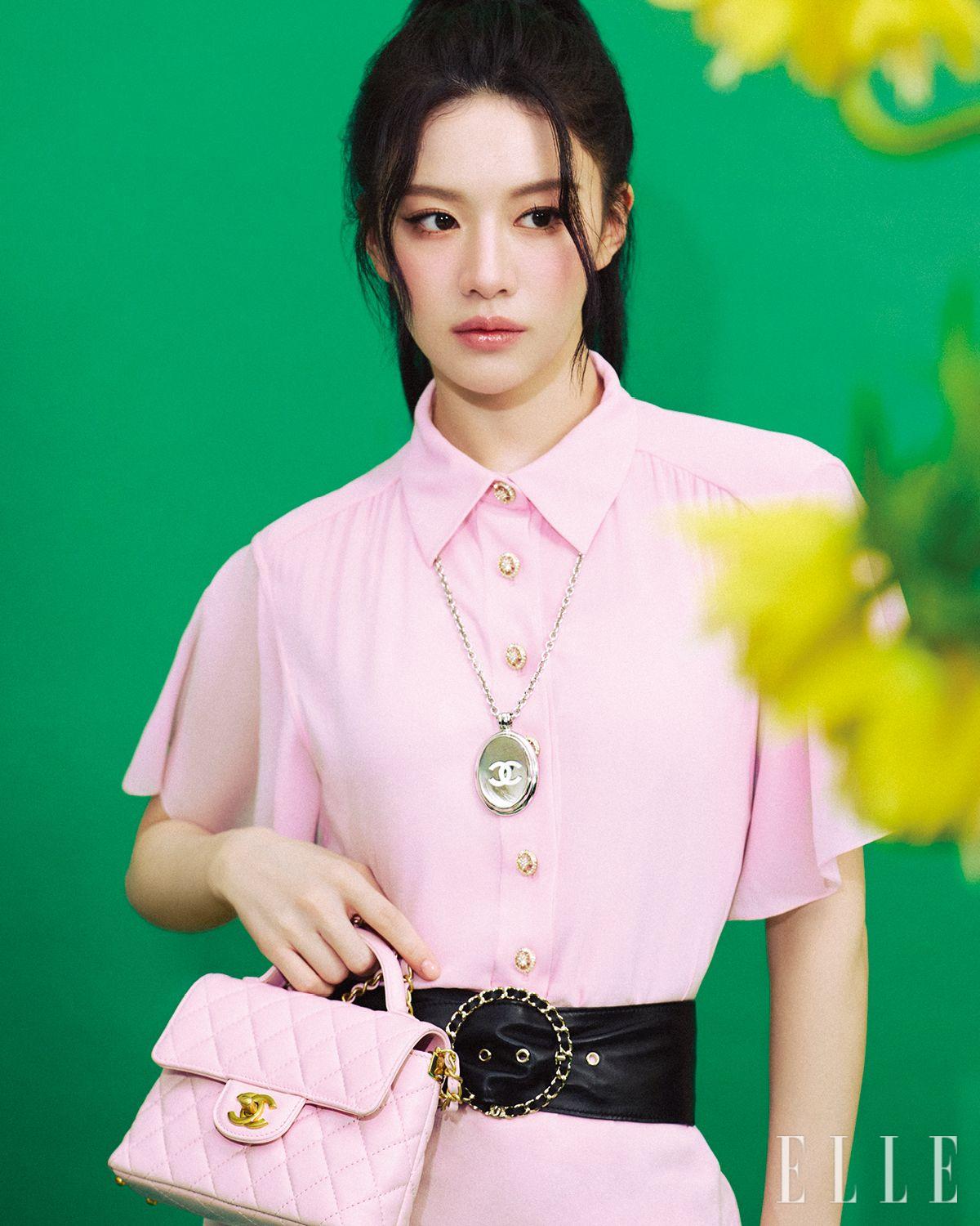 핑크 실크 드레스와 와이드 벨트, 로고 네크리스, 메탈릭 카프스킨 스몰 플랩 백은 모두 Chanel.