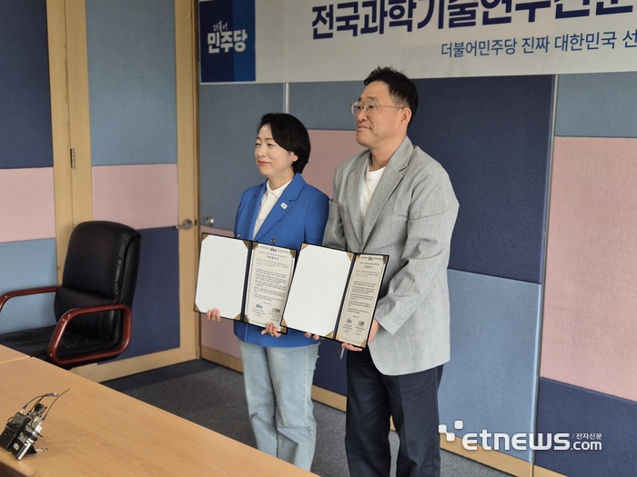 황정아 민주당 중앙선대위 과학기술혁신위원장(왼쪽)과 김재성 전국과학기술연구전문노동조합 위원장이 21일  21대 대선 정책 협약을 맺고 협약서를 들어보이고 있다.