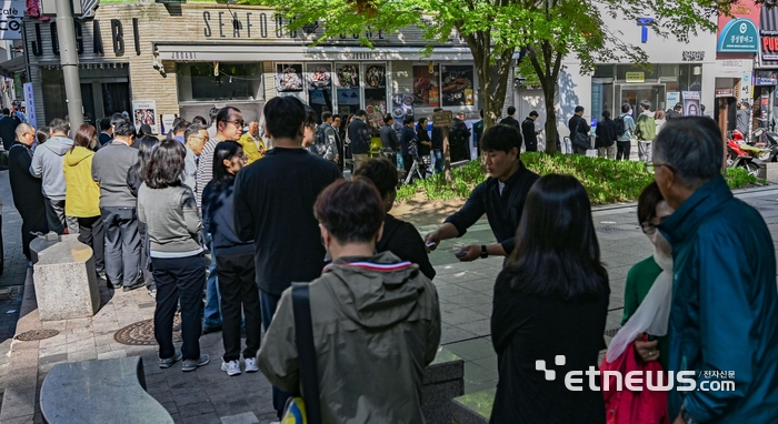 SK텔레콤이 유심 해킹 사고와 관련해 전국 T월드 매장에서 희망 고객을 대상으로 무료 유심 교체를 진행하는 가운데 교체 첫 날인 28일 서울 중구 SKT PS&M 을지로점 앞에서 관계자가 이용자들에게 번호표를 나눠주고 있다. 이동근 foto@etnews.com