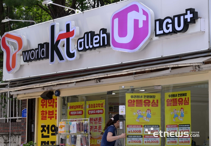 SK텔레콤 유심칩 해킹 사태가 촉발한 통신사 보조금 경쟁이 치열해지고 있다. 주말 서울 시내 한 이동통신사 대리점 앞을 지나는 시민들. 김민수기자 mskim@etnews.com