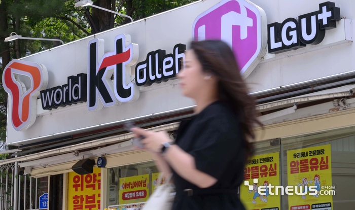 SK텔레콤 유심 정보 해킹 사태가 촉발한 이동통신 3사간 보조금 경쟁이 치열해지고 있다. 주말 서울 시내 한 이통사 대리점 앞을 지나는 시민들. 김민수기자 mskim@etnews.com