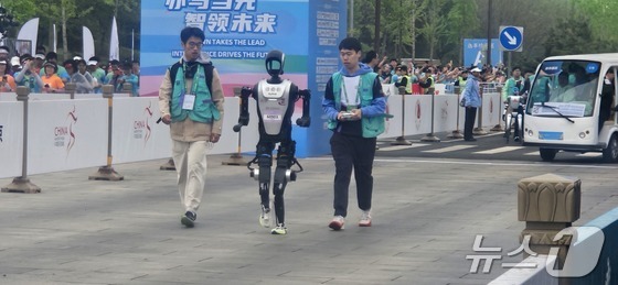 A humanoid robot runs during the humanoid robot half marathon in the Yizhuang Economic Development Zone in Beijing, China, on April 19