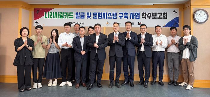 KT Enterprise부문 공공사업본부장 유용규 전무(앞줄 왼쪽에서 일곱 번째)와 군인공제회C&C 김원태 사장(앞줄 왼쪽에서 여섯 번째)이 ‘국방 나라사랑카드 발급 및 운영시스템 구축’ 사업 착수보고회에서 단체 기념사진을 촬영하는 모습ⓒKT
