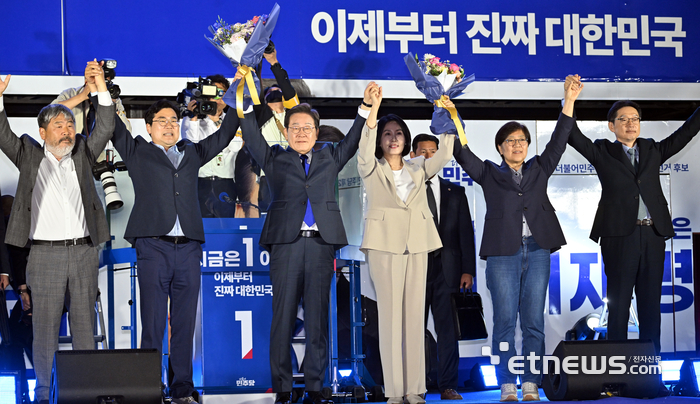 제21대 대통령 선거 당선이 확실시 된 이재명 더불어민주당 후보가 지난달 4일 새벽 서울 여의도 의사당대로에서 열린 국민 개표방송 행사에서 지지자들을 향해 손 흔들고 있다. 김민수기자 mskim@etnews.com