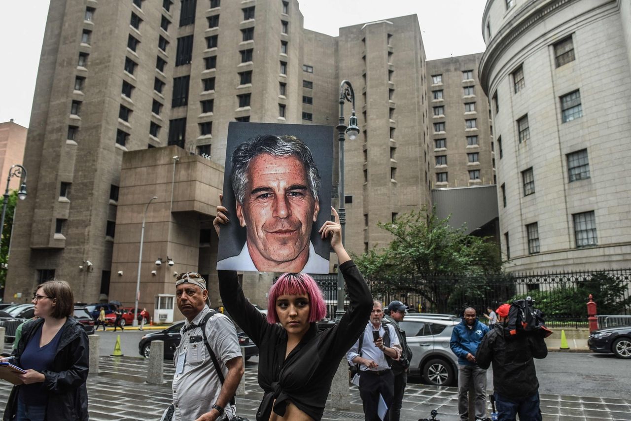 A protester holds up a photo of Jeffrey Epstein in front of the Metropolitan Correction Center in New York City, July 8, 2019. (AFP-Yonhap)]