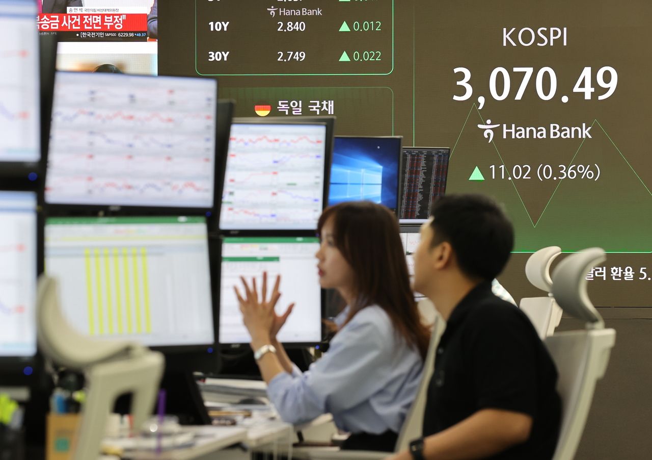 Officials work at a dealing room of Hana Bank in Seoul on Tuesday. (Yonhap)]