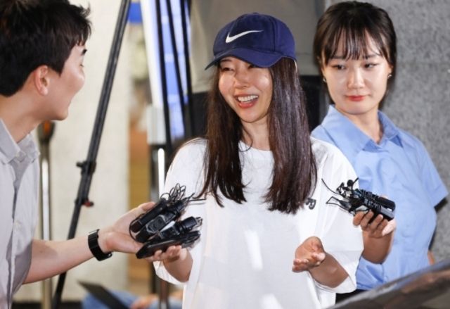 Former Ador CEO Min Hee-jin (center) speaks to reporters while leaving Yongsan Police Station in Seoul on July 9, following questioning over an alleged breach of trust. (Newsis)]