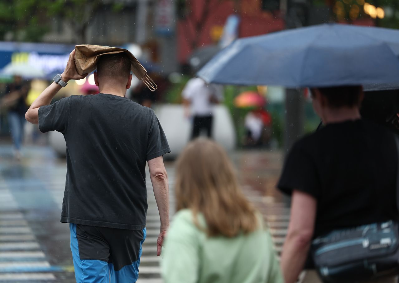 Pedestrians walk across the rain on Monday at Jongno-gu, central Seoul, as the city saw total rainfall of up to 13.6 millimeters that day. (Yonhap)]