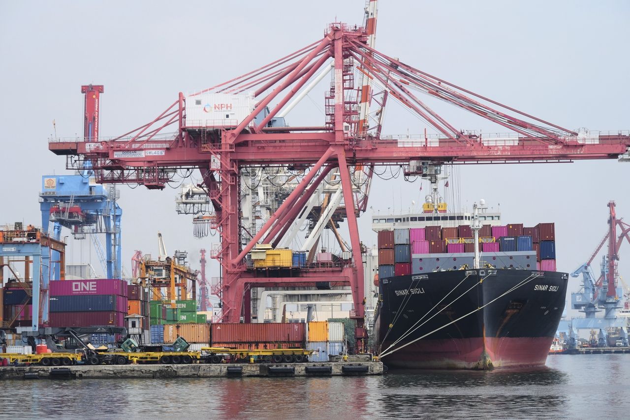 Cranes load shipping containers onto a cargo ship at Jakarta International Container Terminal at Tanjung Priok Port in Jakarta, Indonesia, July 9. AP-Yonhap]