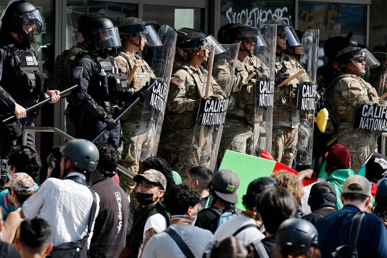 US Police and National Guard members protect a federal building during a protest in Los Angeles, June 9. (AFP-Yonhap)]