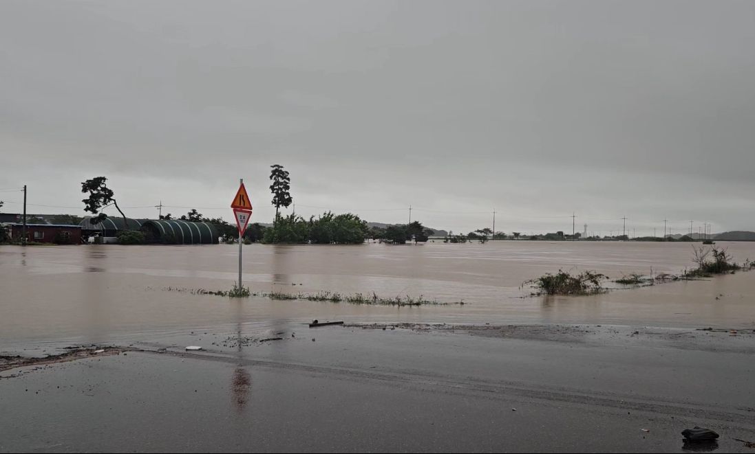 A road in a village in Seosan, South Chungcheong Province, are seen submerged by heavy rain Thursday. (Yonhap)]