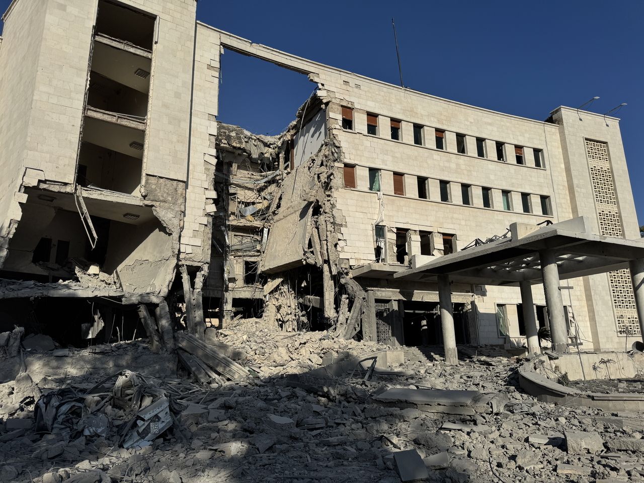 The damaged Syrian Ministry of Defense building, which houses the military]