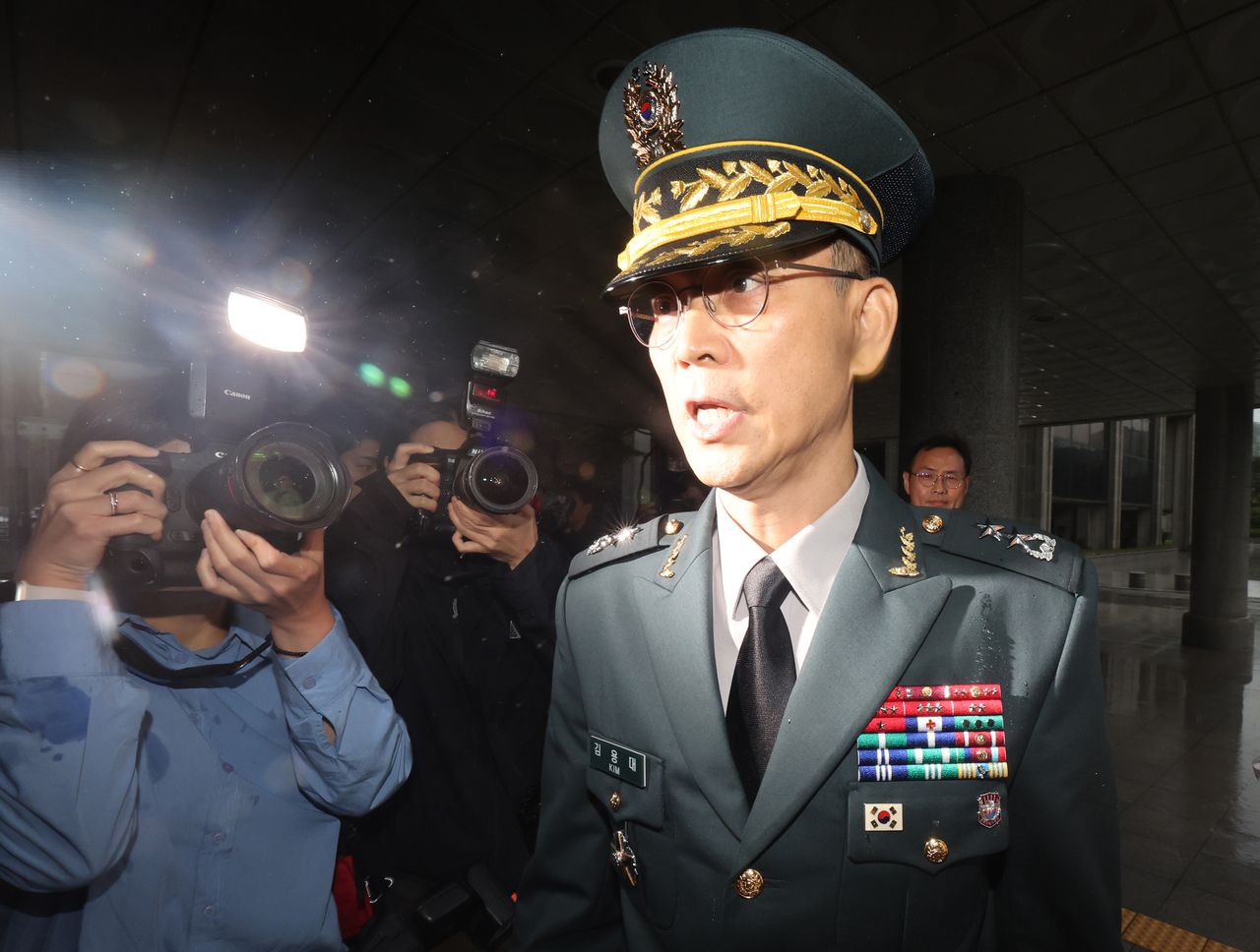 Maj. Gen. Kim Yong-dae (right), commander of the Drone Operations Command, speaks to reporters as he arrives at the Seoul High Prosecutors' Office in Seocho-gu, Seoul, on Thursday. (Yonhap)]
