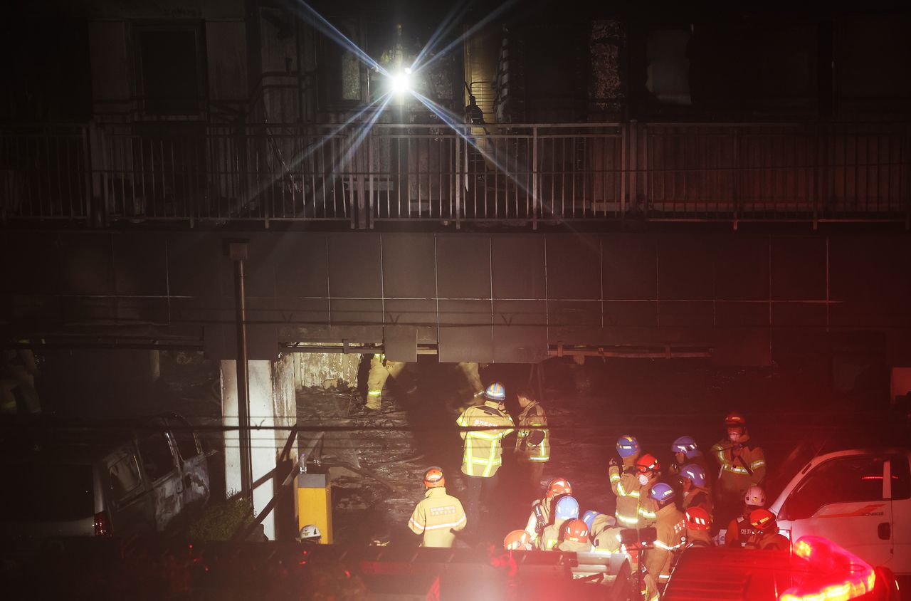 Firefighters are seen inside a gutted apartment building in Soha-dong, Gwangmyeong, Gyeonggi Province, following a fire. (Yonhap)]
