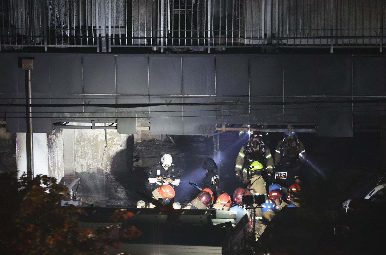 Firefighters conduct search and rescue operations at an apartment building in Gwangmyeong, south of Seoul, on Friday, following a fire that broke out the previous day. (Yonhap)]