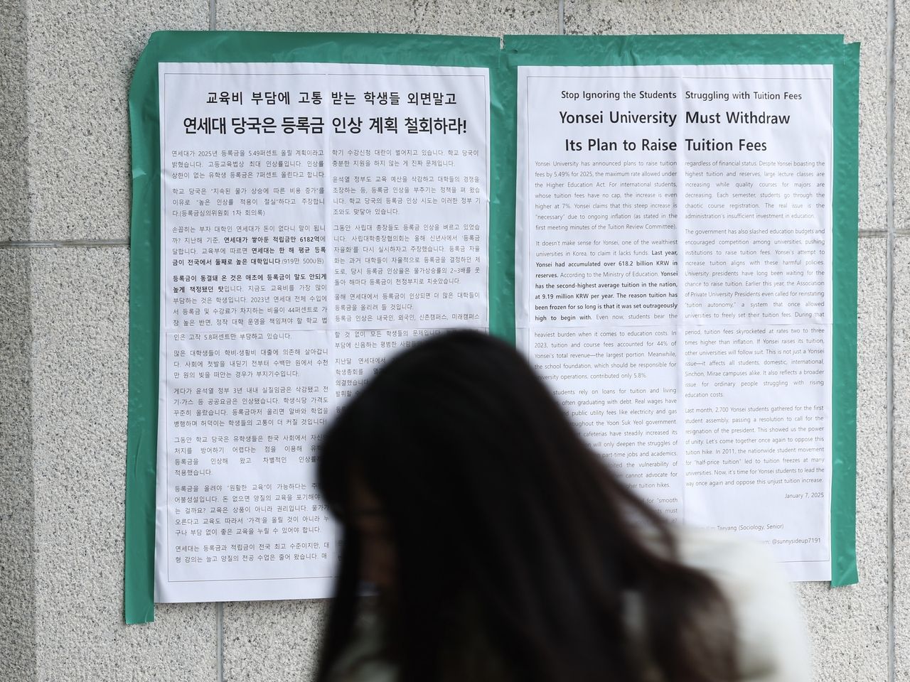 A student walks past protest posters at Yonsei University in Seoul urging the school administration to cancel its planned tuition increase in this photo taken on Jan. 20, 2025. Despite student opposition, the university approved its first undergraduate tuition hike in 15 years just four days later, raising fees by 4.98 percent. (Citizens' Alliance for Free and Standardized University Education)