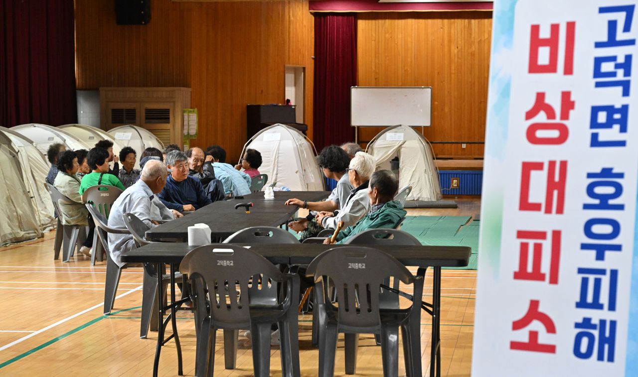 Evacuees gather at an emergency shelter set up at Koduk Middle School in Yesan-gun, South Chungcheong Province, Friday. In Yesan-gun, flooding amid heavy rainfall prompted the evacuation of 751 people and caused nearly 2,900 cases of significant property damage. (Im Se-jun/The Korea Herald)