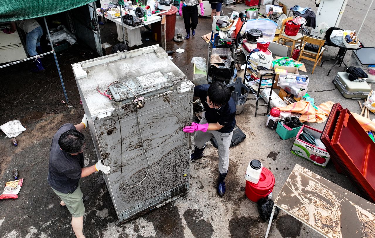 Residents and public officials conduct recovery work on Friday at a house in Daegu flooded by record-breaking heavy rainfall the previous day. (Yonhap)]