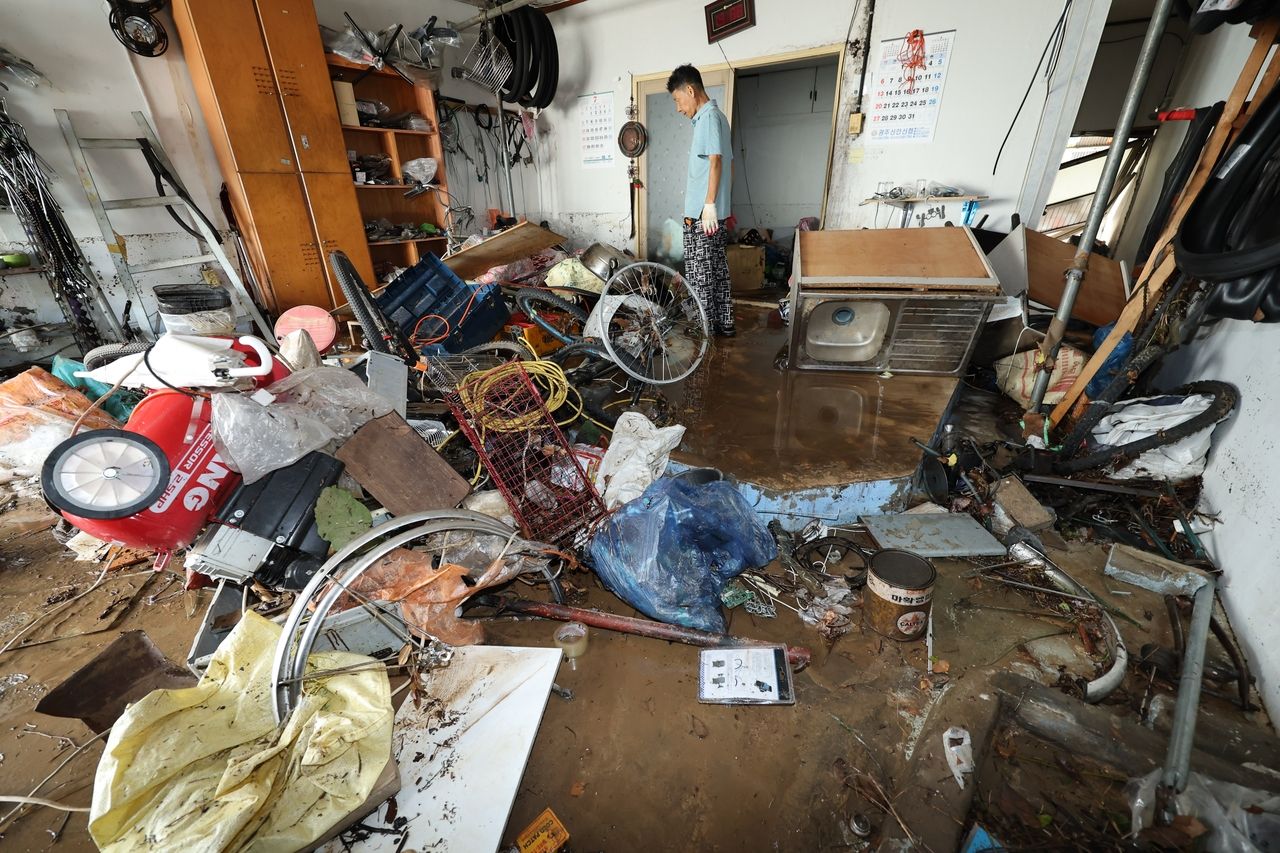 Mud and damaged belongings cover the floor of a shop in Gwangju’s Buk-gu area on Friday following severe flooding on Thursday. (Yonhap)