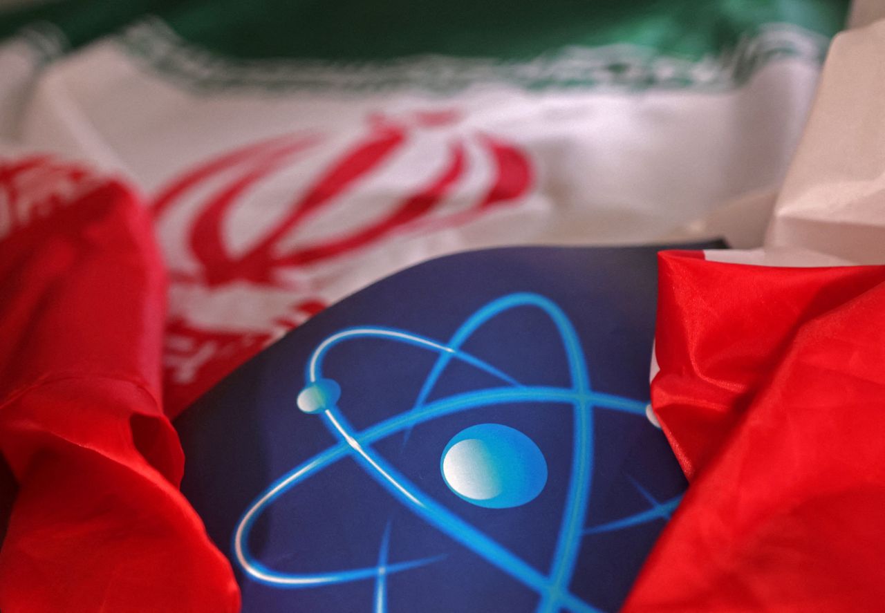 Atomic symbol and Iranian flag are seen in an illustration. (Reuters-Yonhap)]