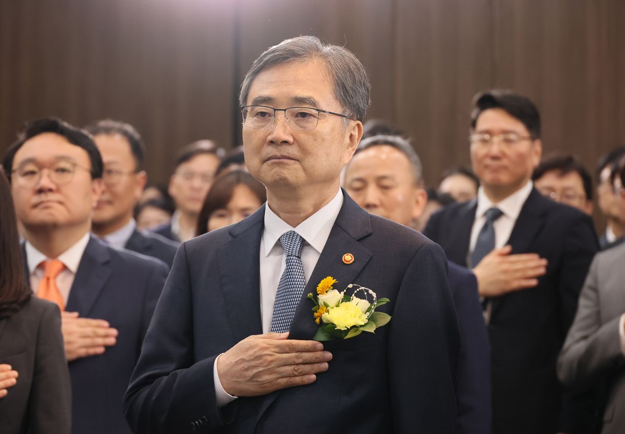 South Korea's new Foreign Minister Cho Hyun stands with his hand over his heart as he looks to the national flag during a ceremony to mark his inauguration at the foreign ministry in Seoul on Monday. (Yonhap)