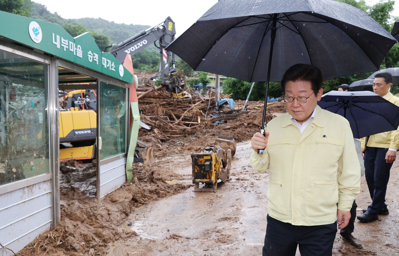 President Lee Jae Myung inspects flood damage during his visit to Sancheong County, 300 kilometers southeast of Seoul, on Monday. (Yonhap)]