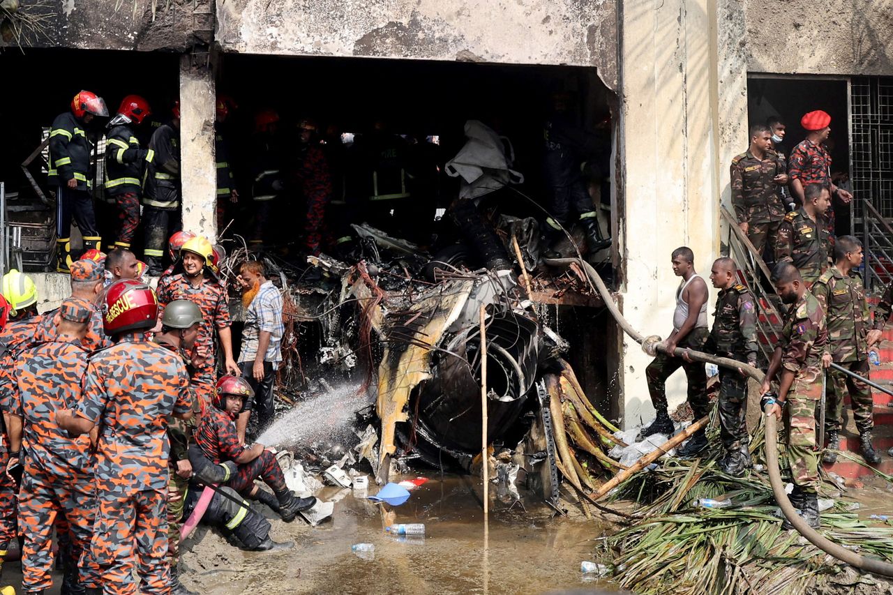 Firefighters and army members work next to the wreckage of an Air Force training aircraft after it crashed into Milestone College campus, in Dhaka, Bangladesh, Monday. (Reuters-Yonhap)]