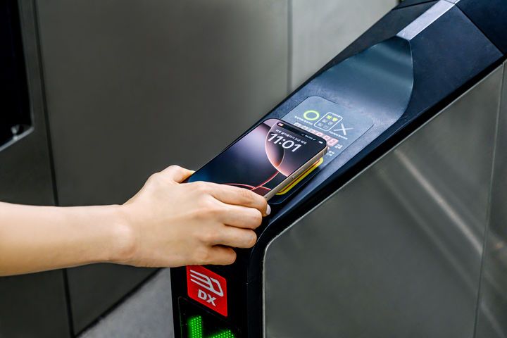 A person taps an iPhone to pay a subway fare using Tmoney via Apple Pay. (Apple)]