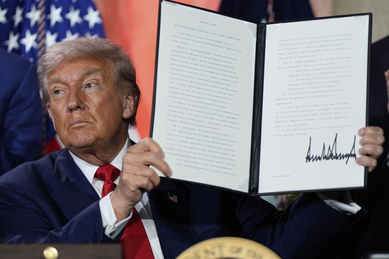 US President Donald Trump holds a signed executive order promoting the export of American AI technology after speaking during an AI summit in Washington, on July 23. (AP-Yonhap)]