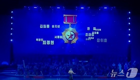 At a celebratory performance held for deployed soldiers, a video showing the names and images of the soldiers is being played / Capture from Korean Central Television