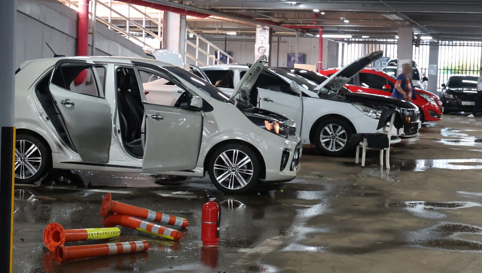 간밤에 내린 폭우로 인천 서구 석남동 인천강남시장 저지대가 침수된 가운데 13일 오전 물이 빠진 공영주차장에서 침수된 차량을 차주들이 물기를 말리고 있다. 2025.08.13. [인천=뉴시스]