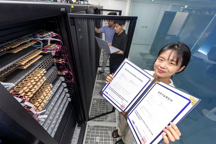 KT 직원이 ‘KT 매니지드 프라이빗 클라우드’로 획득한 국가정보원의 보안기능확인서를 들고 있는 모습ⓒKT