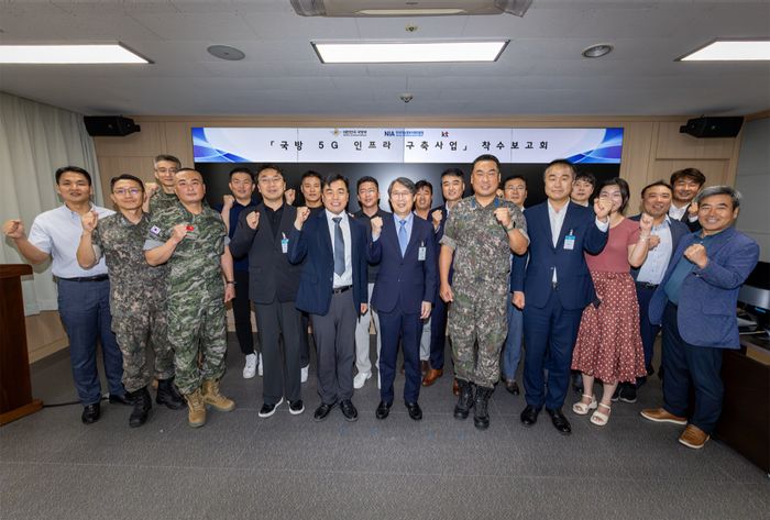 KT Enterprise부문 이행1본부장 이진권 상무(앞줄 왼쪽부터 6번째)와 국방부, 한국지능정보사회진흥원(NIA) 주요 관계자가 ‘국방 5G 인프라 구축’ 사업 착수보고회에서 단체 기념사진을 촬영하는 모습ⓒKT