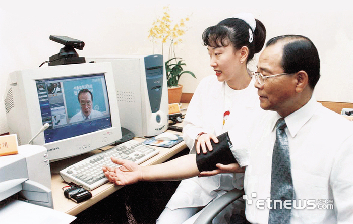 한국통신과 서울대병원은 1999.07.23일 PC와 인터넷을 통해 집이나 직장에서 의료서비스를 받을 수 있는 원격클리닉 시범서비스에 돌입했다. 이계철 한국통신 사장(오른쪽)이 시범진료를 받고 있다. 〈1999.07.24일 1면〉