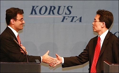 김현종 통상교섭본부장(오른쪽)과 카란 바티아 미 무역대표부(USTR) 부대표가 2007년 4월 2일 서울 한남동 하얏트호텔 리젠시룸에서 협상결과에 대해 발표 후 악수를 나누고 있다.
