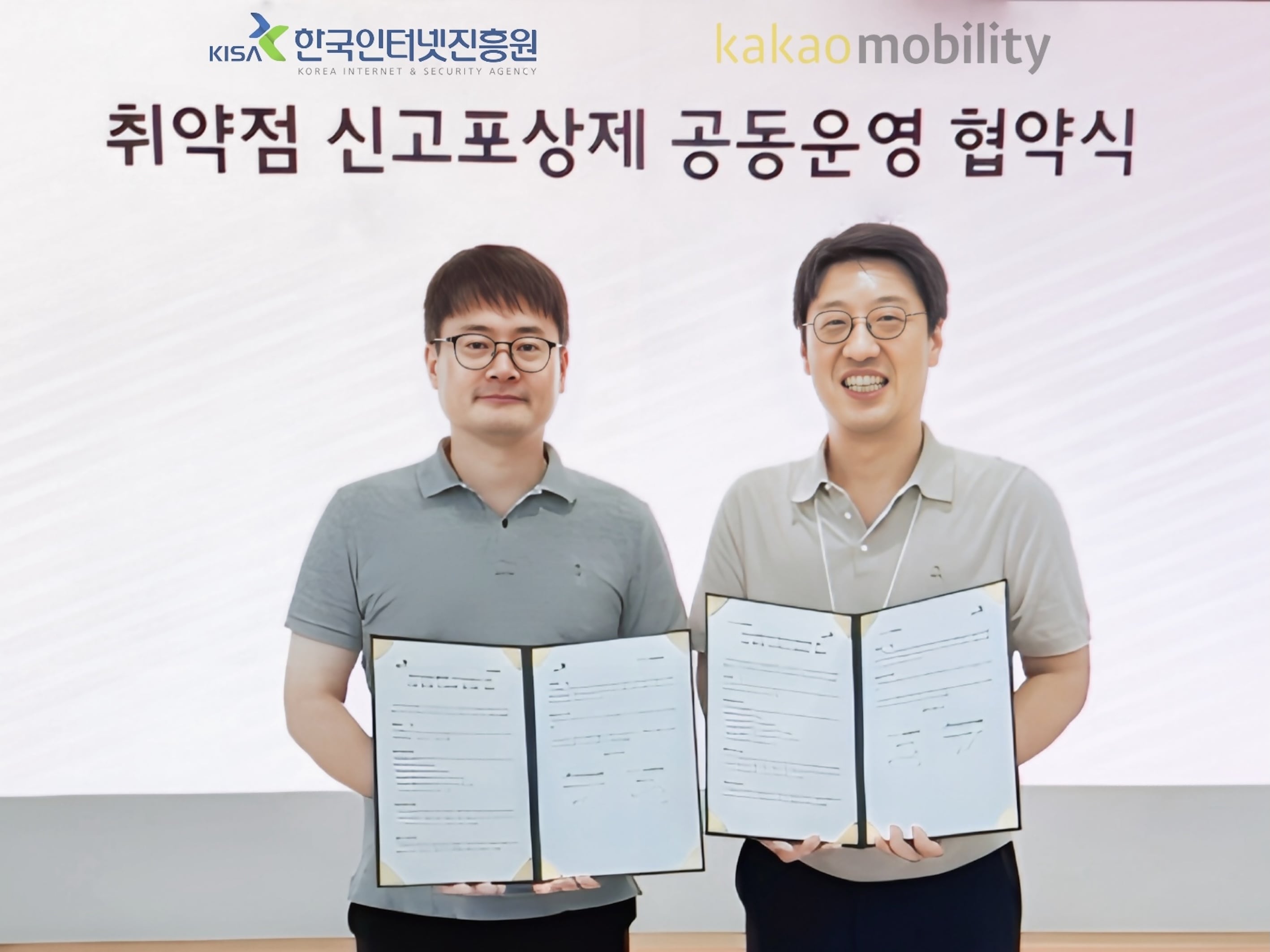 이동근 한국인터넷진흥원(KISA) 디지털위협대응본부 본부장(왼쪽)과 카카오모빌리티 정보보호최고책임자인 최진욱 상무가 5일 경기 성남시 카카오모빌리티 본사에서 업무 협약식 진행 후 사진촬영을 하고 있다. /카카오모빌리티 제공