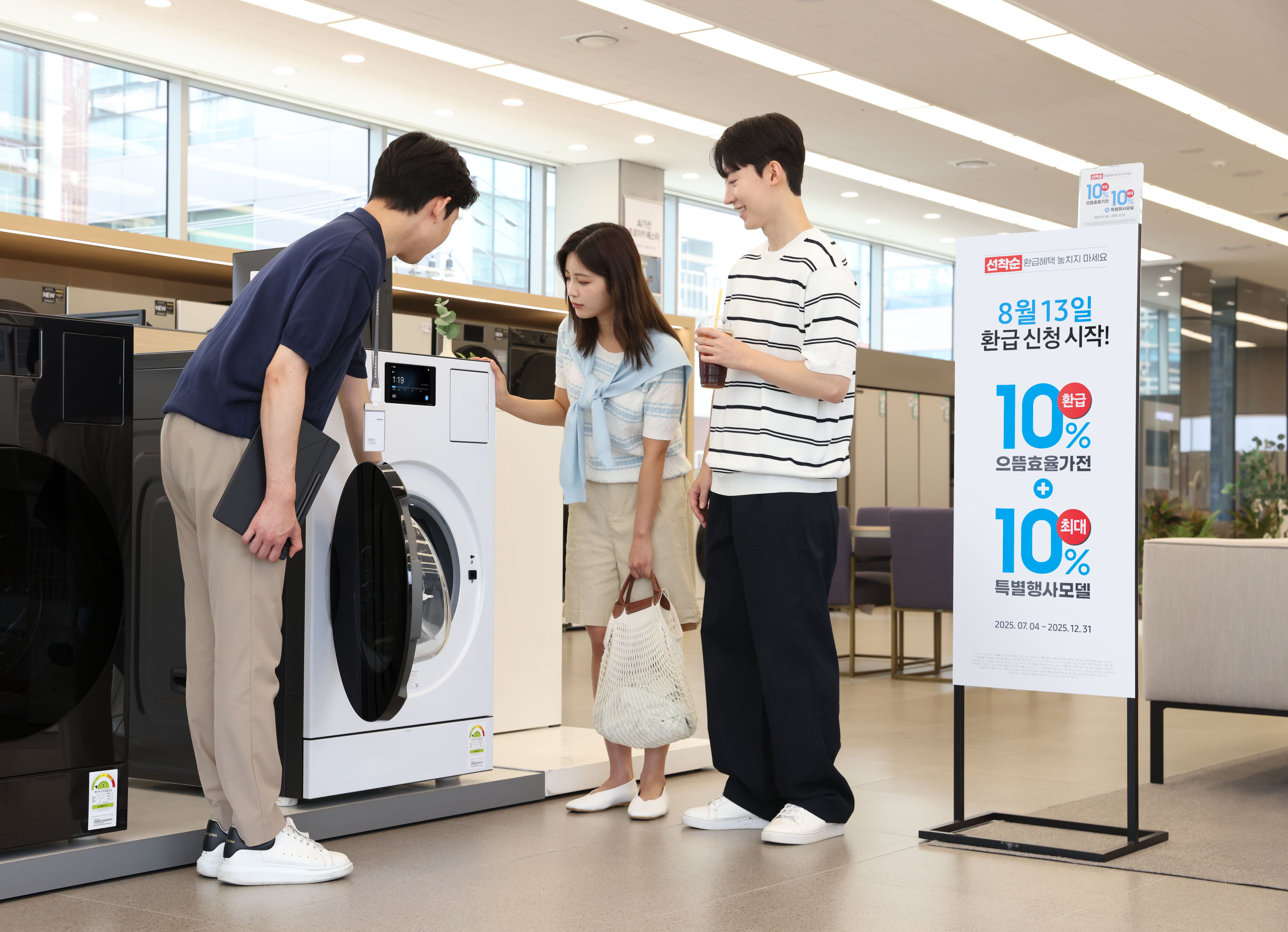 삼성전자 모델이 에너지 소비효율 1등급의 '세탁건조기'와 '에어컨' 제품의 설명을 듣고 있다./삼성전자 제공