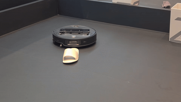 5축 로봇 팔이 달린 로보락 로봇청소기가 청소 중 슬리퍼를 인식하고 본체에서 로봇 팔을 꺼내 슬리퍼를 들어 올리고 있다./최지희 기자