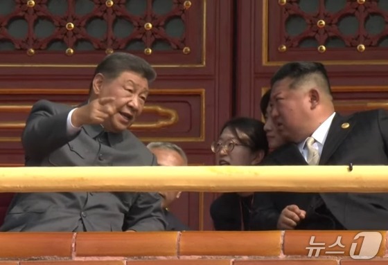 A scene capturing Chinese President Xi Jinping and North Korean Workers\' Party General Secretary Kim Jong Un in conversation during the Victory Day parade in Beijing, China on Wednesday. The event commemorated the 80th anniversary of victory in the Anti-Japanese War and the Anti-Fascist War / Capture from China\'s state-run CCTV YouTube broadcast