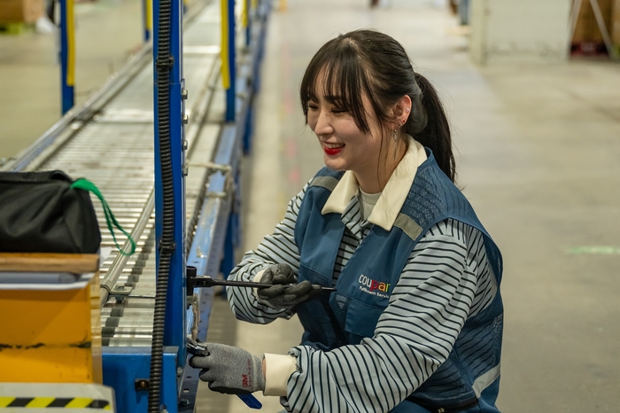 박소진 CFS 오토메이션 엔지니어가 풀필먼트센터에서 자동화 설비 롤러 컨베이어를 정비하고 있다.