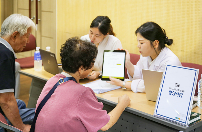 지난 16일 경기도 성남시에 위치한 성남시니어산업혁신센터에서 진행된 '그리팅 X SCL 시니어 웰니스 프로그램'에서 현대그린푸드 영양사들이 성남시 거주 노인분들께 건강검진을 제공하고 있다.