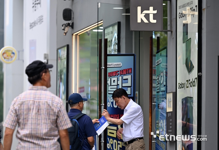 KT 가입자들의 집단 소액결제 피해가 발생한 가운데 과학기술정보통신부가 9일 민관합동조사단을 구성해 현장조사 등 원인조사에 착수한다. 이날 시민이 서울 시내 한 KT판매점 앞을 지나고 있다.  이동근기자 foto@etnews.com